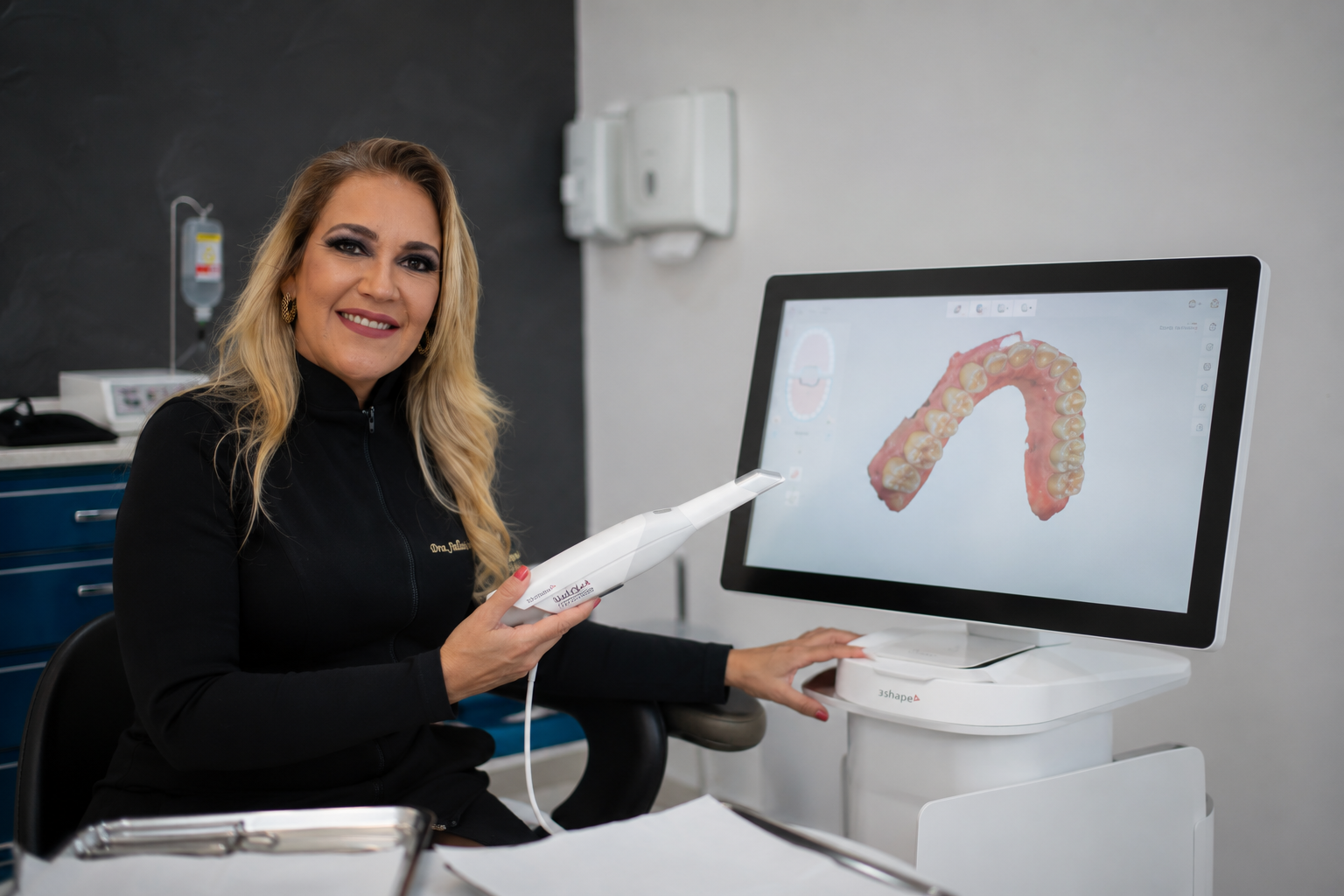 Dra. Juliana utilizando scanner intraoral 3Shape com escaneamento 3D exibido na tela